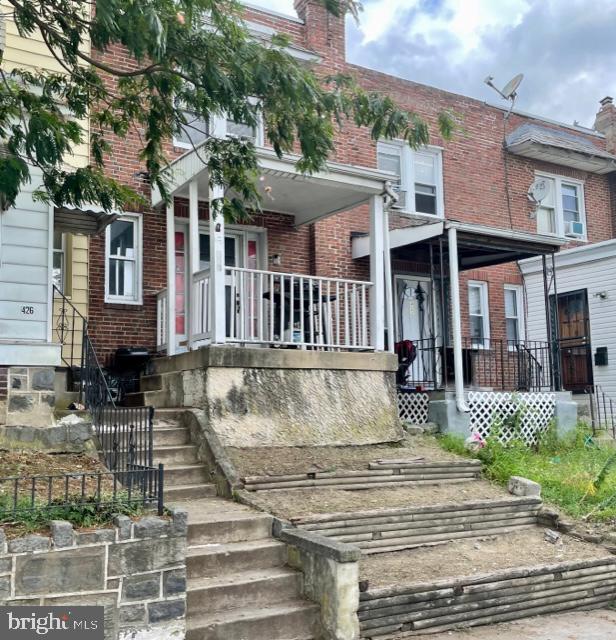 multi unit property with a porch and brick siding