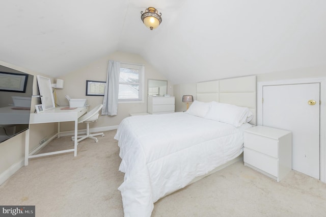 bedroom featuring light carpet and vaulted ceiling