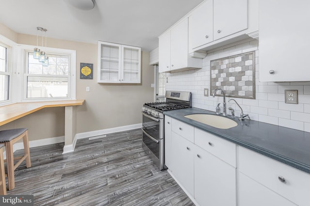 kitchen with white cabinetry, double oven range, pendant lighting, and sink