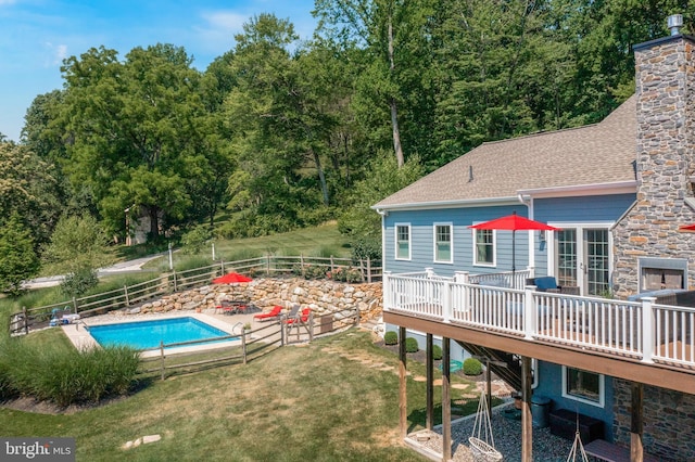 view of swimming pool with a yard, a wooden deck, a fenced in pool, and fence