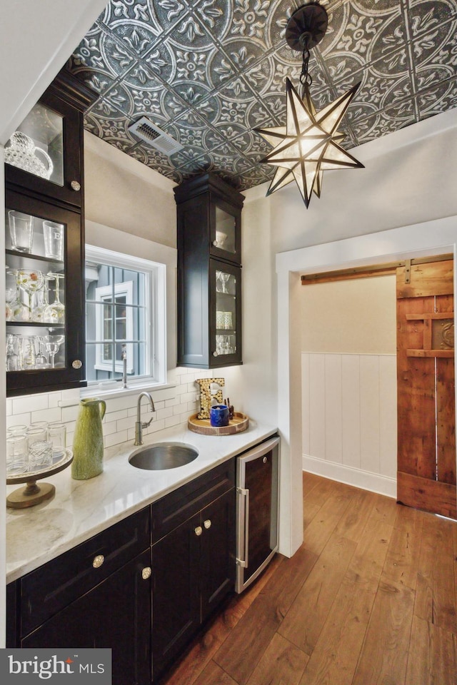 bar with an ornate ceiling, wine cooler, decorative backsplash, and a sink