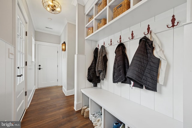 mudroom featuring baseboards, dark wood-type flooring, visible vents, and crown molding