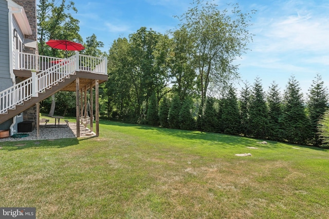 view of yard featuring a wooden deck and stairs