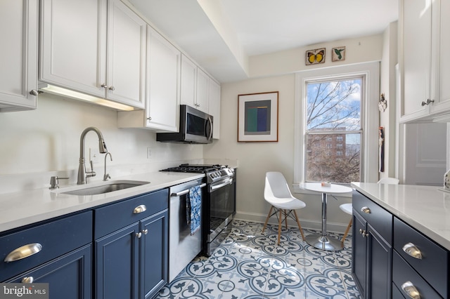 kitchen featuring light tile patterned flooring, sink, white cabinets, stainless steel appliances, and blue cabinetry