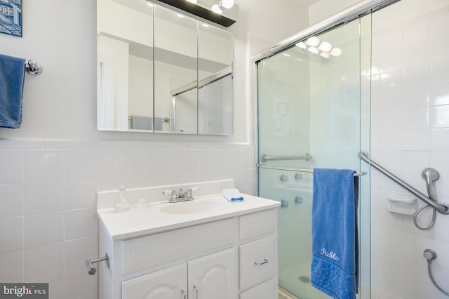 bathroom with vanity, tile walls, and walk in shower