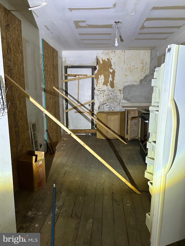 basement featuring dark wood-type flooring and white refrigerator