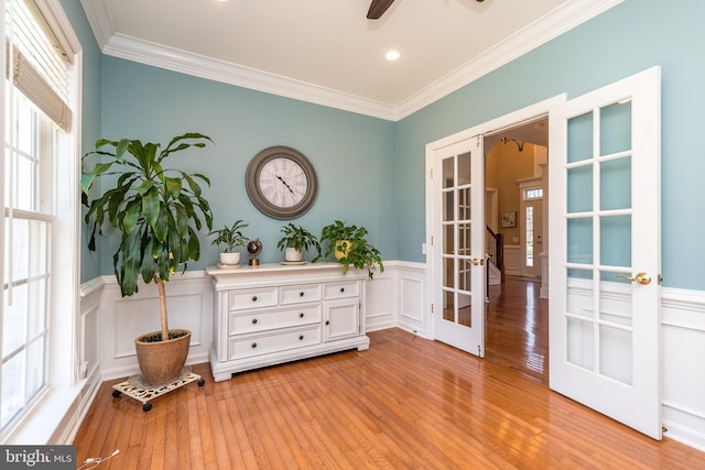 living area with french doors, light wood-style flooring, and crown molding