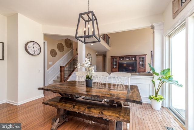 dining area featuring stairs, visible vents, wood finished floors, and baseboards