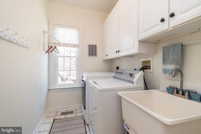 clothes washing area featuring visible vents, a sink, cabinet space, baseboards, and washing machine and clothes dryer