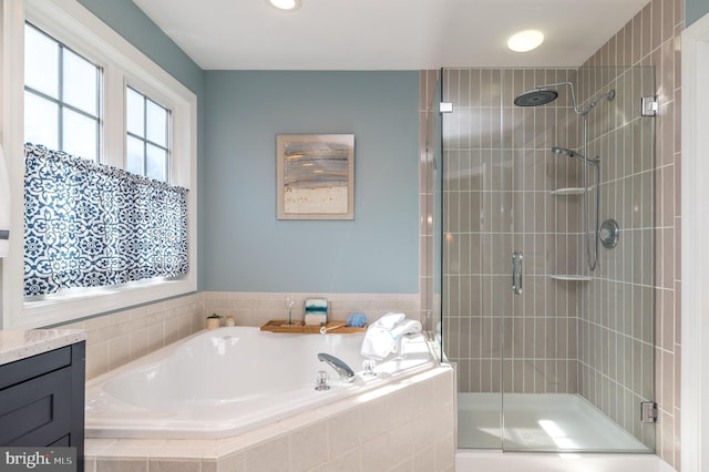 bathroom with vanity, a bath, and a shower stall