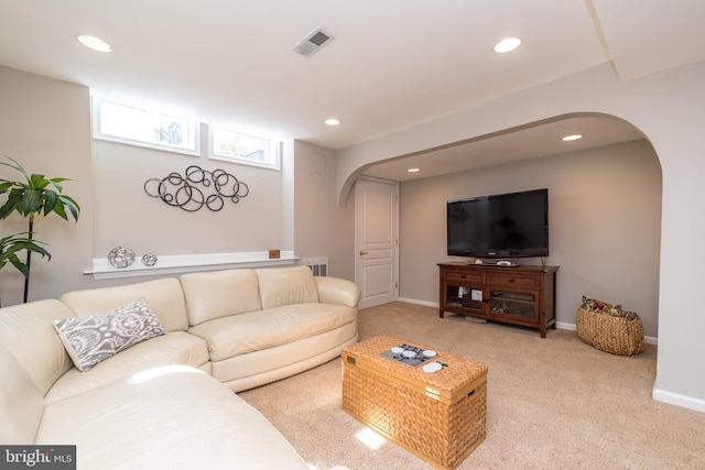 carpeted living area featuring recessed lighting, visible vents, arched walkways, and baseboards