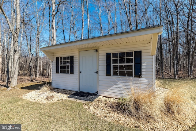 view of outdoor structure with an outbuilding and a forest view