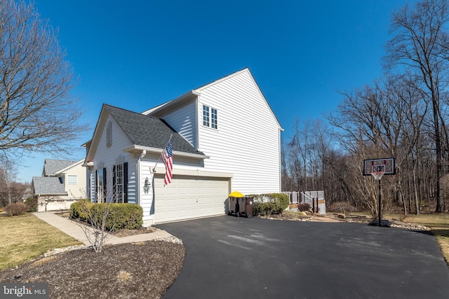 view of property exterior with aphalt driveway, roof with shingles, and an attached garage