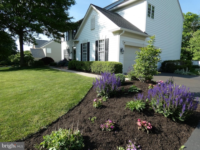 view of home's exterior featuring driveway and a yard