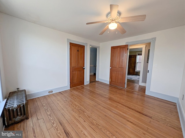 unfurnished bedroom with light wood finished floors, baseboards, and a ceiling fan