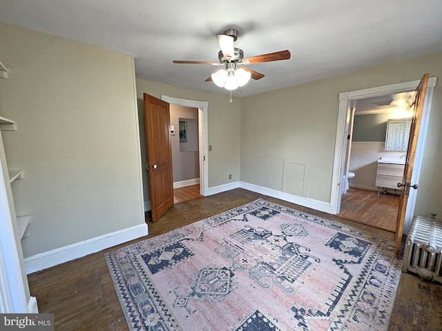 unfurnished bedroom featuring dark wood-style floors, baseboards, and a ceiling fan