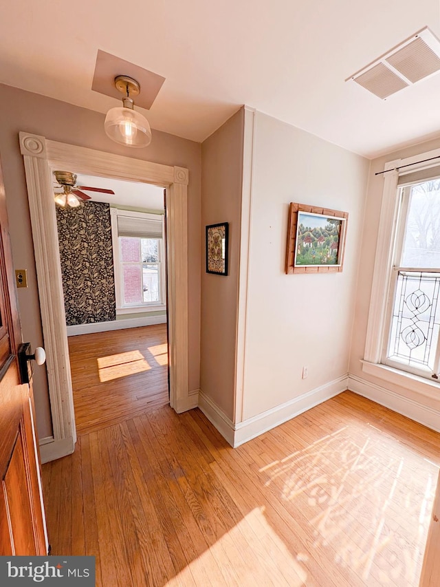 interior space with baseboards, plenty of natural light, visible vents, and wood finished floors