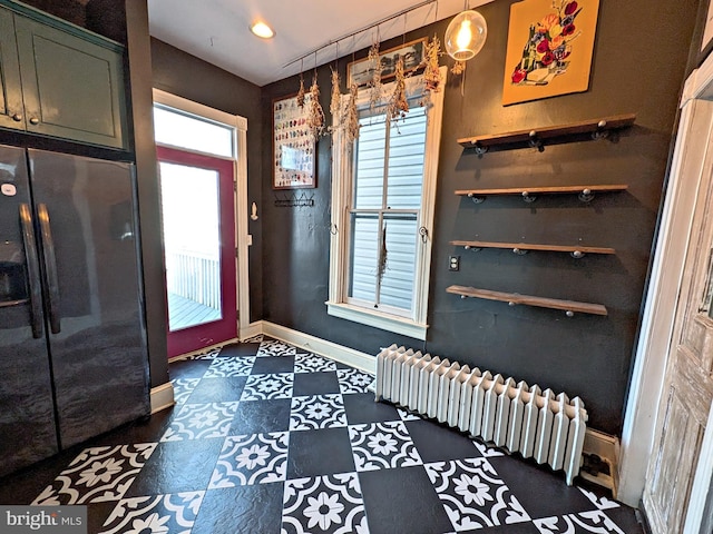 mudroom featuring baseboards, dark floors, and radiator