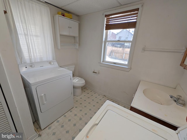 full bathroom with toilet, vanity, baseboards, tile patterned floors, and washer / clothes dryer