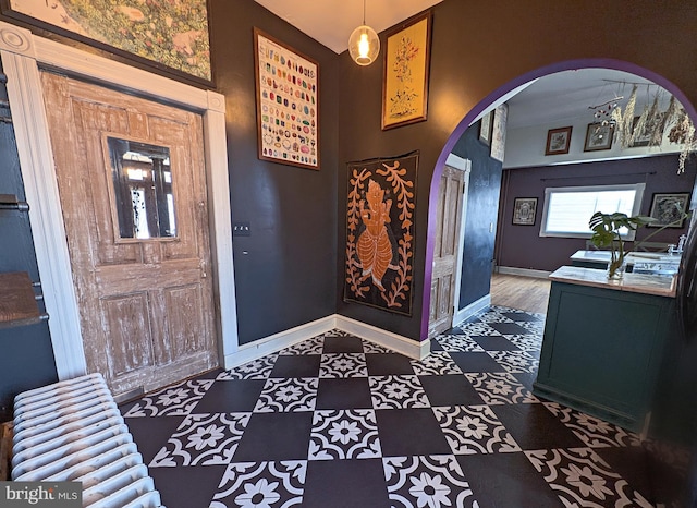 entryway featuring arched walkways and baseboards