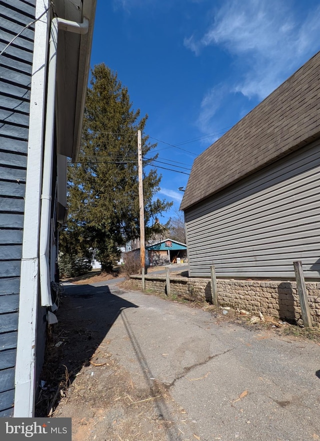 exterior space featuring roof with shingles