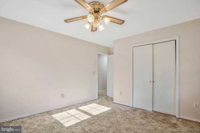 unfurnished bedroom featuring light carpet, a closet, and ceiling fan