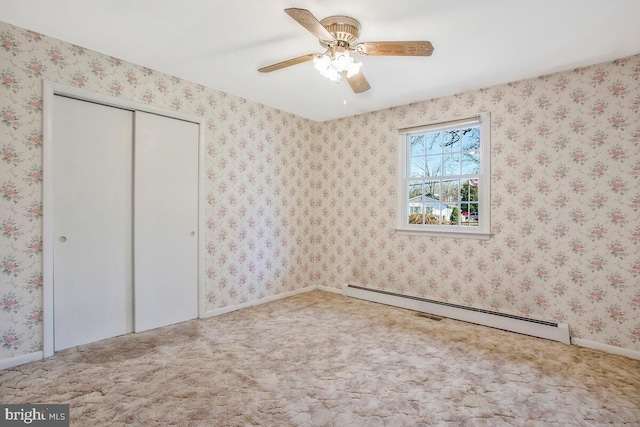 unfurnished bedroom featuring ceiling fan, carpet, baseboard heating, and a closet