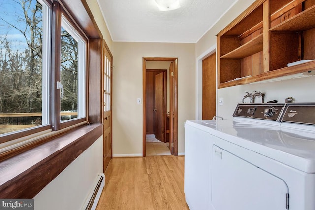 washroom featuring washer and dryer, light hardwood / wood-style floors, and a textured ceiling