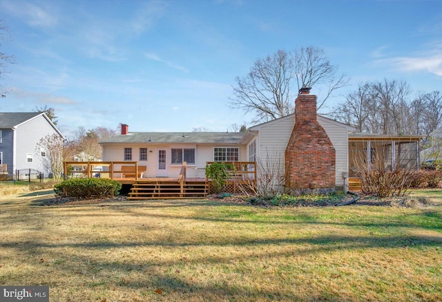 rear view of property with a deck and a lawn