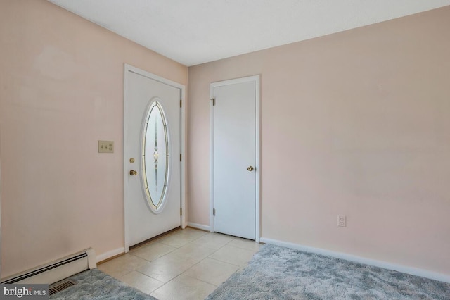 foyer entrance with light tile patterned floors and a baseboard heating unit