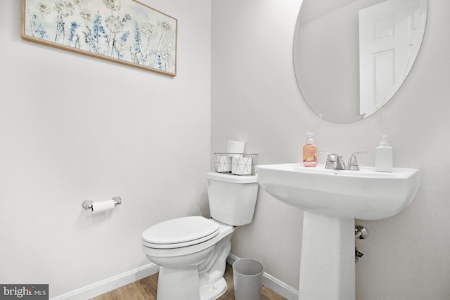 bathroom featuring toilet, baseboards, and wood finished floors