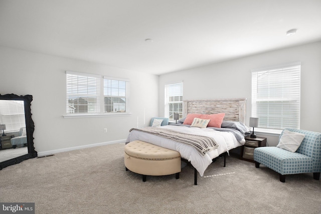 bedroom featuring multiple windows, carpet, visible vents, and baseboards