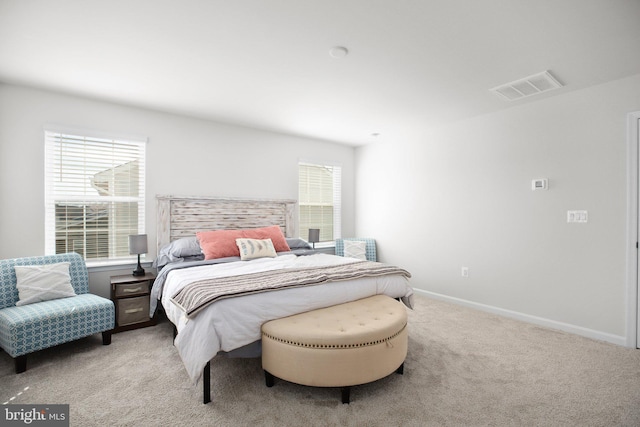 bedroom with light carpet, visible vents, and baseboards