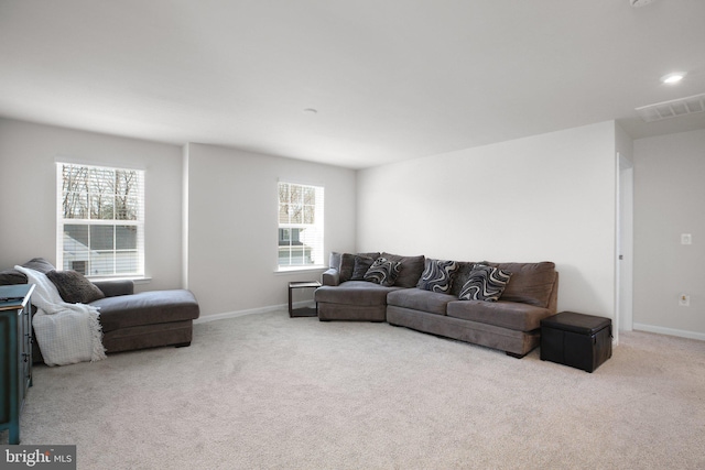 carpeted living area featuring baseboards and visible vents