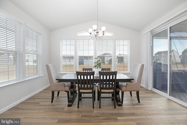 dining room with baseboards, vaulted ceiling, a notable chandelier, and wood finished floors