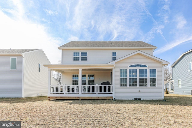 back of house with covered porch and a lawn