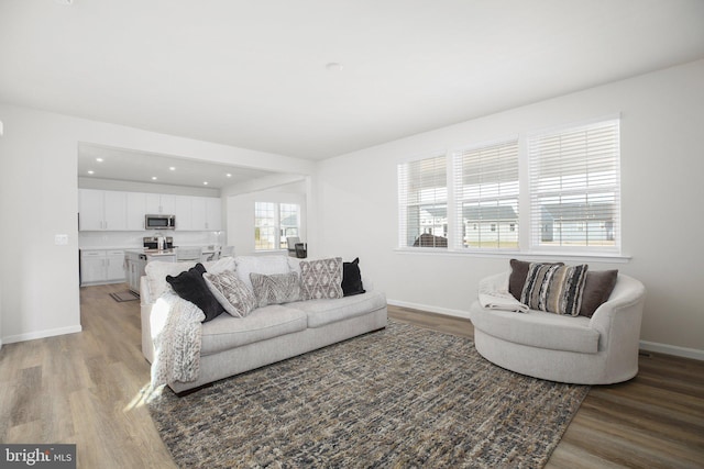 living room featuring recessed lighting, light wood-type flooring, and baseboards