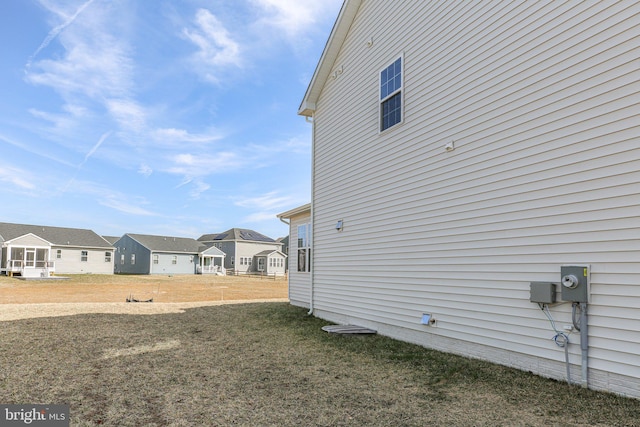 view of side of home featuring a residential view and a lawn