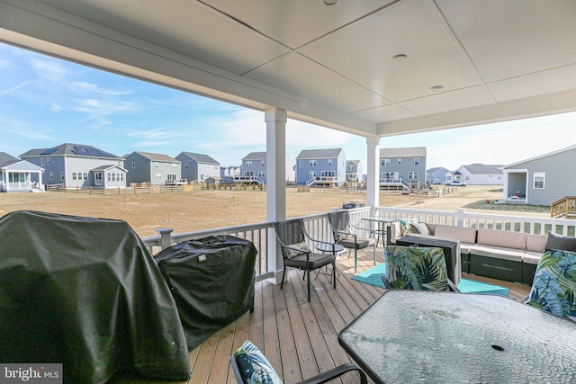 wooden deck with a residential view, a grill, and an outdoor living space