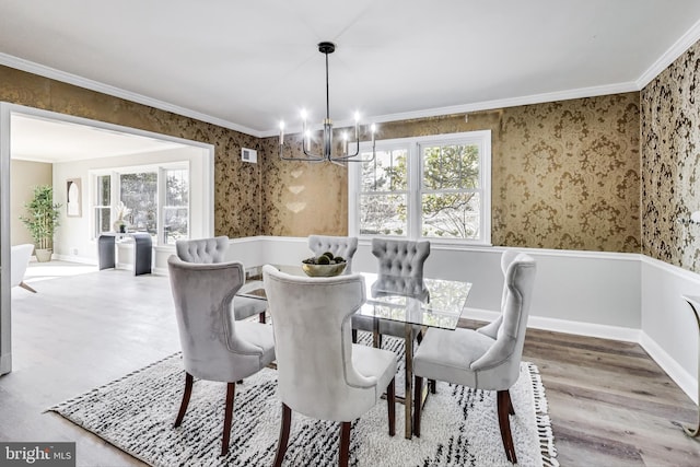 dining space featuring hardwood / wood-style flooring, crown molding, and an inviting chandelier