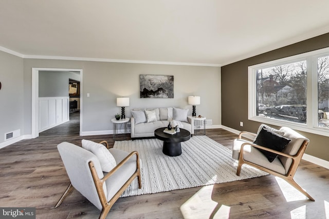 living room with dark wood-type flooring and ornamental molding