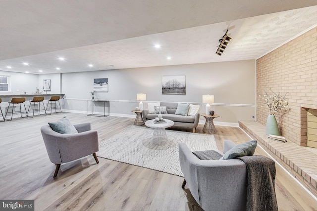 living room with brick wall and light hardwood / wood-style floors