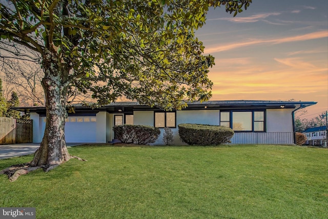 view of front of property with a yard and a garage