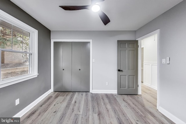 unfurnished bedroom featuring light hardwood / wood-style floors, a closet, and ceiling fan