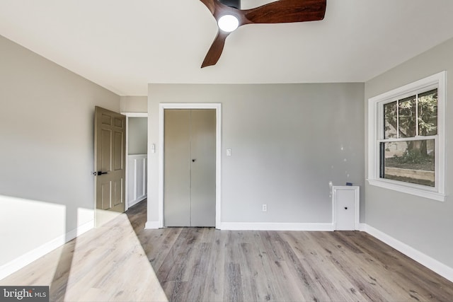 unfurnished bedroom featuring ceiling fan, light hardwood / wood-style floors, and a closet