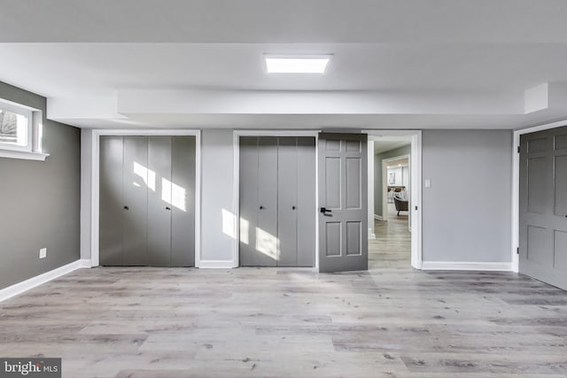 interior space with multiple closets and light wood-type flooring