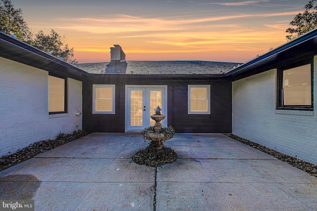 exterior entry at dusk with a patio area