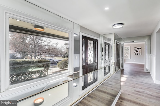 corridor with wood-type flooring and french doors