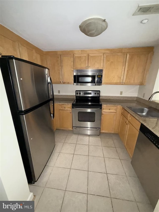 kitchen featuring stainless steel appliances, visible vents, a sink, and light tile patterned floors