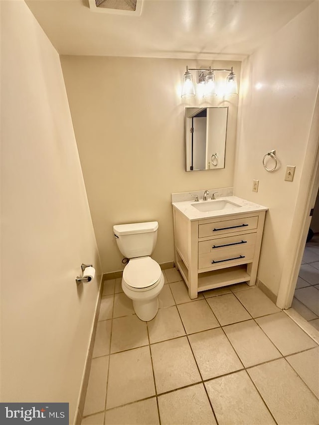 bathroom with baseboards, vanity, toilet, and tile patterned floors